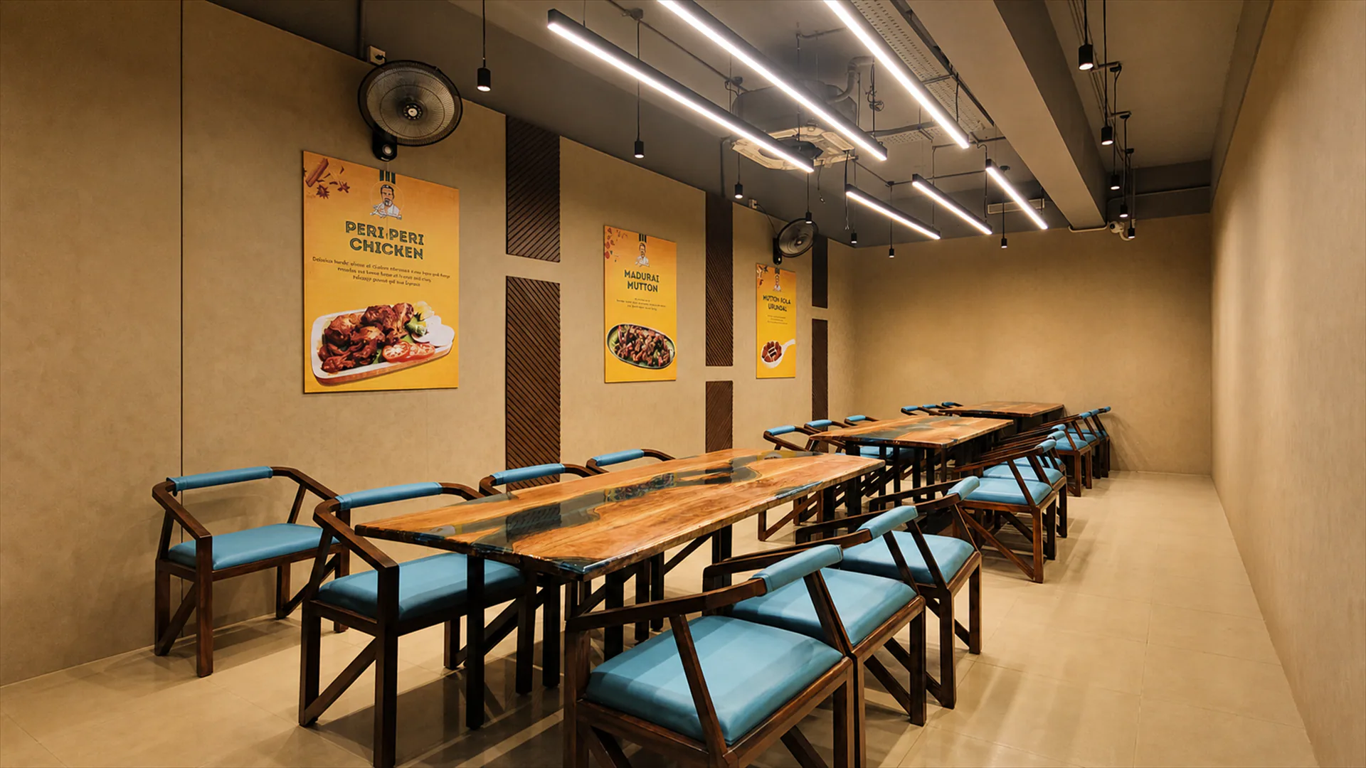Dining area with long communal tables, turquoise chairs and framed wall graphics.