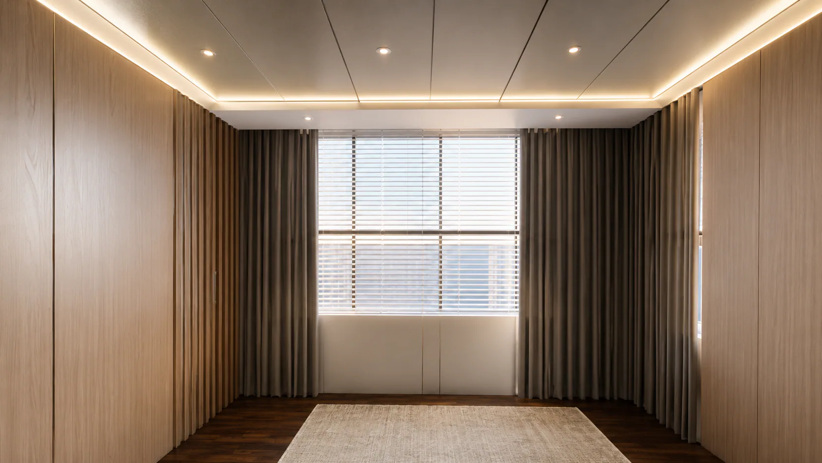 Daylit unfurnished room with timber wall panels and full-height curtains.