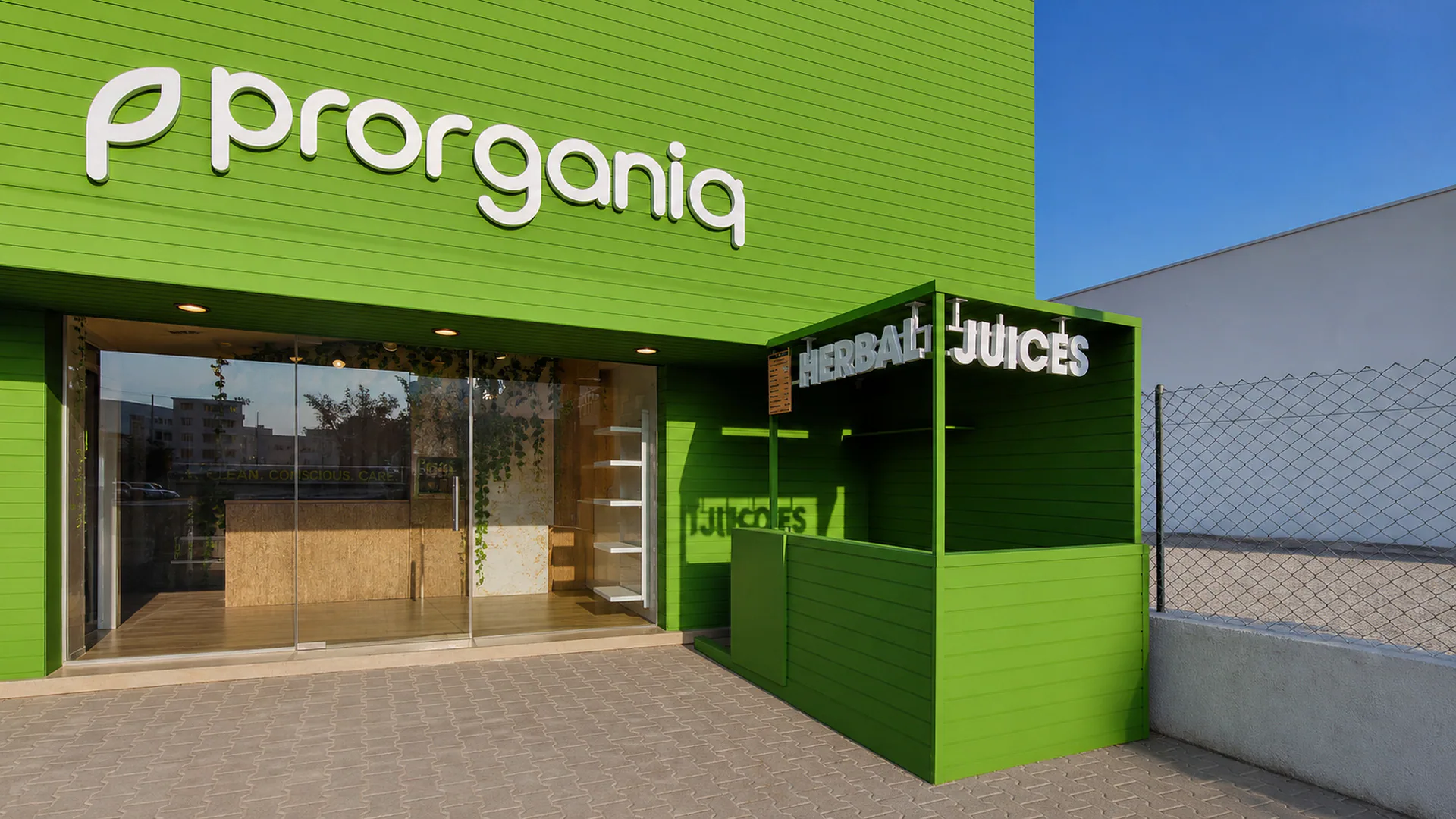 Close exterior view of the green Prorganiq storefront and glazed entrance.