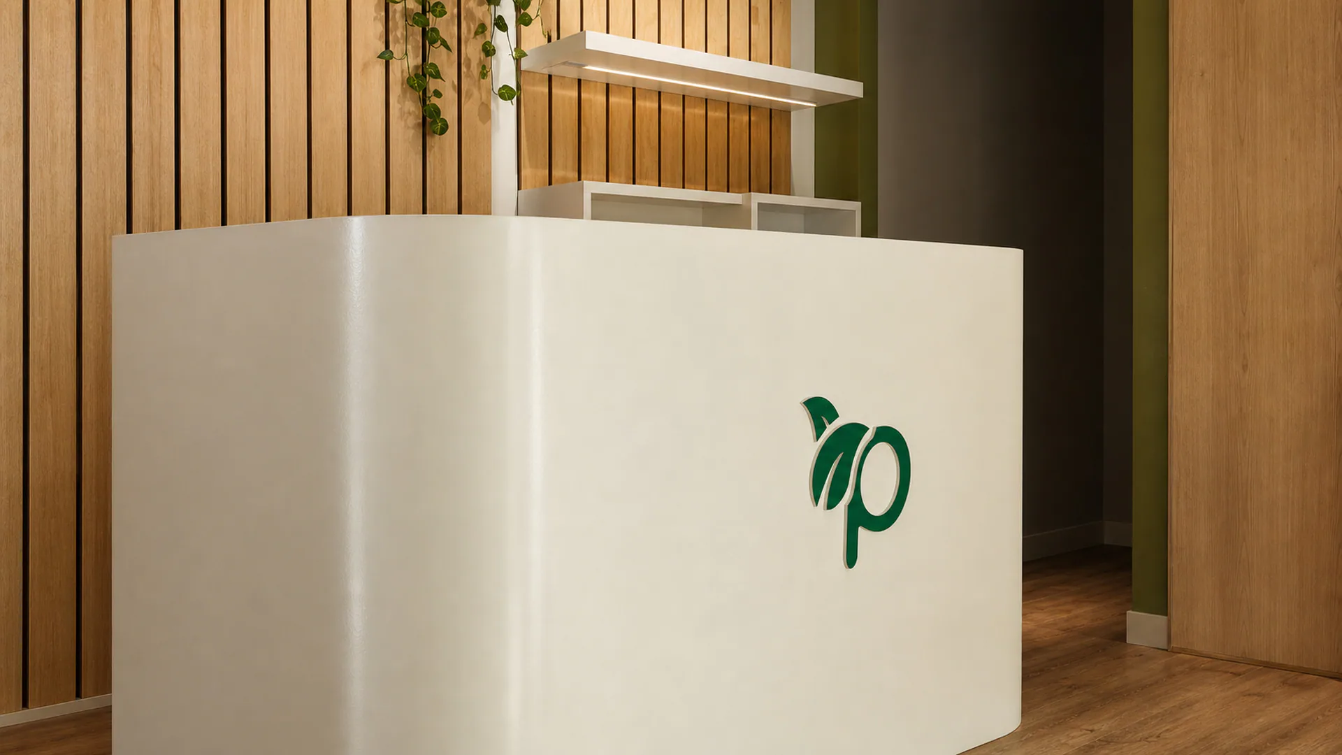 Close view of the white reception desk with the green Prorganiq symbol.