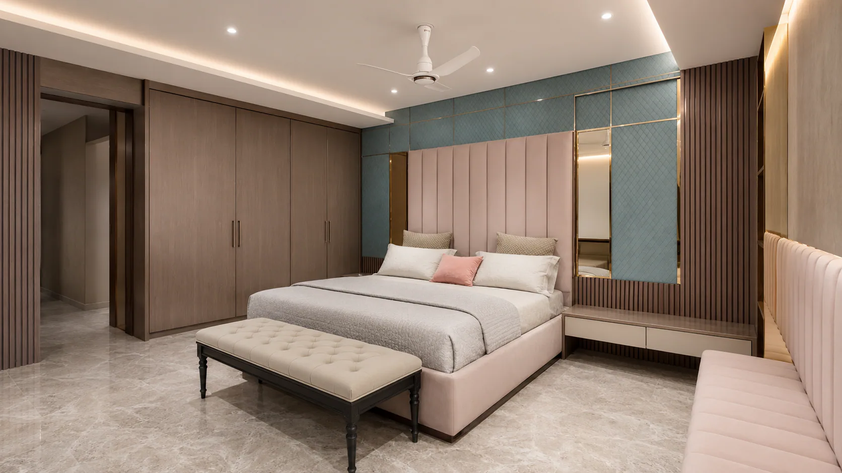Reverse view of the bedroom with a pink upholstered bed and teal wall panels.